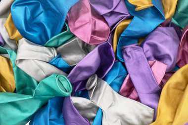 Renkli sönmüş balonların arka plan dokusunun üst görüntüsü. Birden fazla renkli şişmemiş balon deseni. Renkli balonlar yığını.