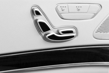 Kapı kolu güç koltuk ileri düğmeleri bir lüks yolcu araba ile. Beyaz deri iç lüks modern araba. Modern araba iç detaylar.