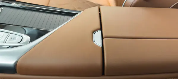 Brown luxury modern car Interior. Detail of modern car interior. Part of brown leather seats with red stitching in expensive car