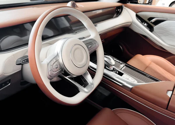 Red luxury modern car Interior. Steering wheel, shift lever and dashboard. Detail of modern car interior. Automatic gear stick. Part of leather seats with stitching