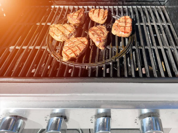 Beef fillet steak on the gas grill. Grilling of beef meat on outdoor gas grill. Grilled meat steak on stainless grill depot