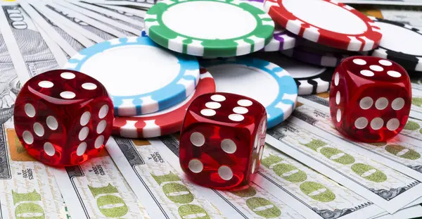 Stack of Poker chips with dice rolls on a dollar bills, Money. Poker table at the casino. Poker game concept. Playing a game with dice. Casino dice rolls.