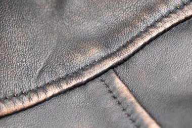 Deri döşeme arka planı. Delikli siyah deri detaylarının bir parçası. Deri dokusu delinmiş. Doku derisi