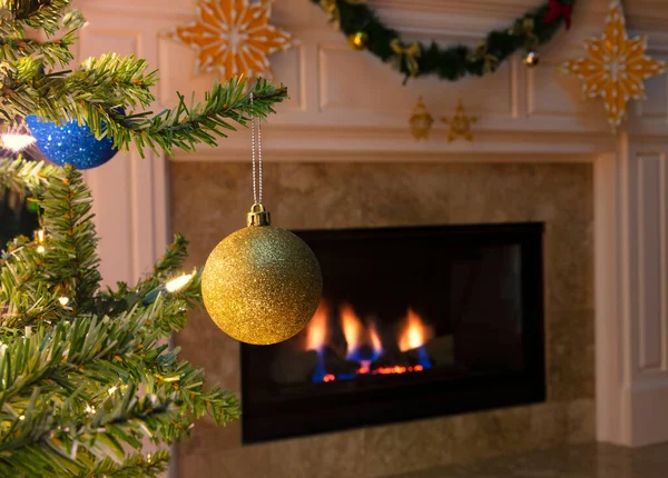 Ağaçtan Sarkan Arka Planda Şöminesi Parlayan Tek Bir Altın Noel — Stok fotoğraf