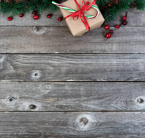 メリークリスマスまたは幸せな新年の背景にモミの先端の枝とギフトボックス素朴な木の板の上に杖で存在 — ストック写真