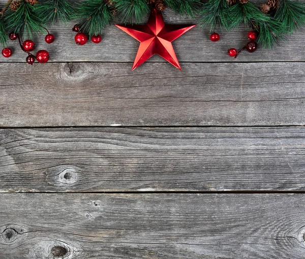メリークリスマスや素朴な木の板にモミの先端の枝や赤い星の装飾と幸せな新年の背景 — ストック写真