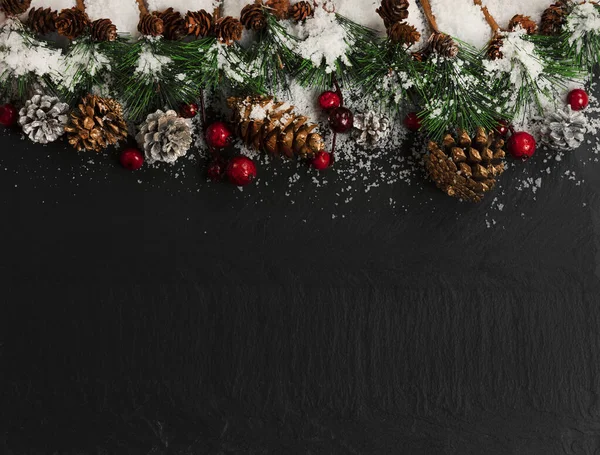 Weihnachtsschnee Tannenzweige Rote Beeren Und Silbergoldene Tannenzapfen Auf Dunklem Steinhintergrund lizenzfreie Stockbilder