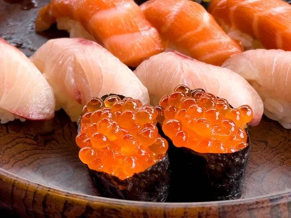 盆盛りを背景に生の黄身の尾と鮭の切り身を入れた寿司鮭の卵を閉じる — ストック写真