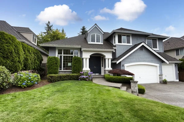 Beautiful home with green grass yard and blooming hydrangea flowers in summer season