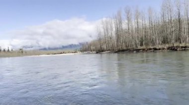 Washington 'daki Sauk nehri bahar mevsiminin başlarında berrak su ve dalgalı bulutlarla çağlayarak dağları aşar.