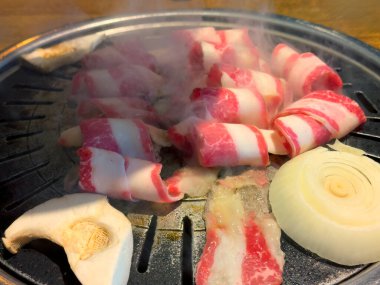 Sıcak tabakta pişmiş çiğ et ve soğan yakın çekim 