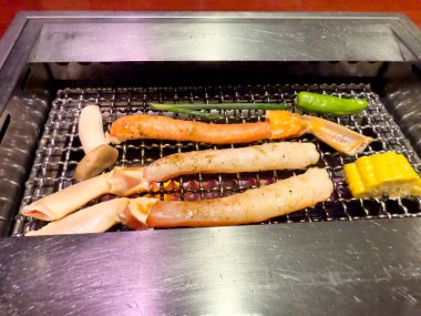 Yengeç bacakları ve mangalda kızartılan sebzeler. 