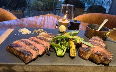Japonya wagyu ve kobe biftek dilimlenmiş taş üzerinde biftek ızgara sebze ve tuzlu baharat ile tahta kesme yakından görünüm 