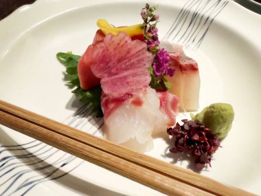 Çiğ deniz ürünleri ya da Japon saşimi akşam yemeği için beyaz tabakta güzel süslemeler. 