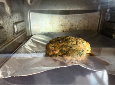 Çiğ somon balığı köftelerinin küçük elektrikli fırında pişirilmesine yakın.  