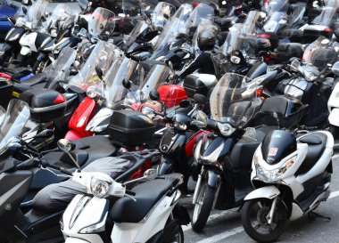 Bir sürü scooter ve motosikletli park yeri.