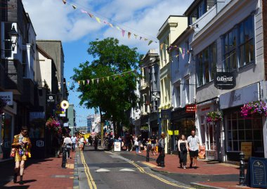 İnsanlar ellerinde süslü süslemelerle sokakta yürüyorlar. Brighton, İngiltere, İngiltere