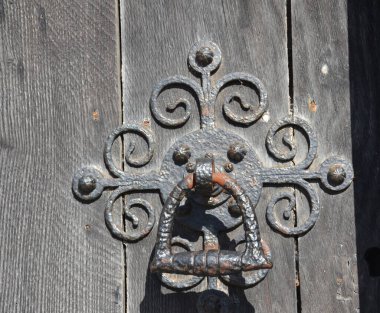 Old iron ornate door knocker on a wooden door of the Salisbury Cathedral, Salisbury, Wiltshire, England, UK clipart