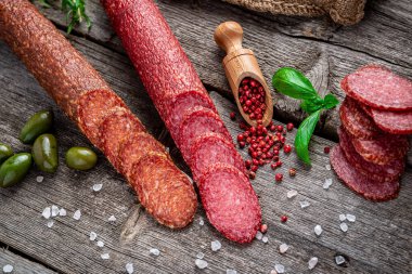 Eski ahşap masada en kaliteli İtalyan salamı. Salam. Kurutulmuş organik salam ya da İspanyol sucuğu.