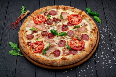 Mozzarella peyniri, salam, tavuk eti, sığır eti, jambon, domates sosu ve biber baharatlı pizza.