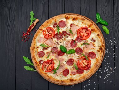 Mozzarella peyniri, salam, tavuk eti, sığır eti, jambon, domates sosu ve biber baharatlı pizza.