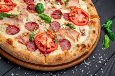 Mozzarella peyniri, salam, tavuk eti, sığır eti, jambon, domates sosu ve biber baharatlı pizza.