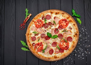 Mozzarella peyniri, salam, tavuk eti, sığır eti, jambon, domates sosu ve biber baharatlı pizza.