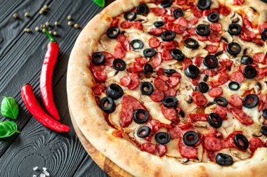 Farklı et çeşitleriyle büyük ve lezzetli bir pizza. Sosisli, tavuklu ve mantarlı İtalyan pizzası.