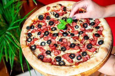 Farklı et çeşitleriyle büyük ve lezzetli bir pizza. Sosisli, tavuklu ve mantarlı İtalyan pizzası.
