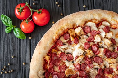 Farklı et çeşitleriyle büyük ve lezzetli bir pizza. Sosisli, tavuklu ve mantarlı İtalyan pizzası.