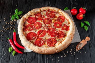 Siyah arka planda pizza margherita, üst manzara. Domates, fesleğen ve Mozzarella peynirli pizza..