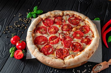 Siyah arka planda pizza margherita, üst manzara. Domates, fesleğen ve Mozzarella peynirli pizza..
