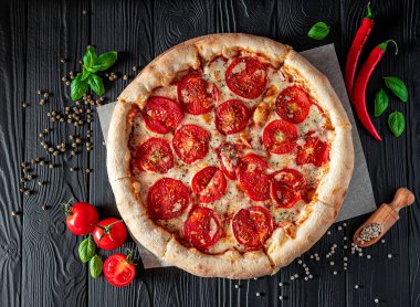 Siyah arka planda pizza margherita, üst manzara. Domates, fesleğen ve Mozzarella peynirli pizza..