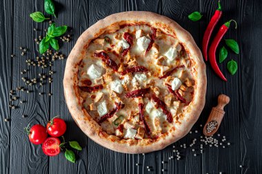 Lezzetli ve farklı et çeşitleriyle büyük pizza. Sıcak pizzanın en iyi manzarası. Kurutulmuş domatesli ve peynirli büyük ve lezzetli bir pizza.