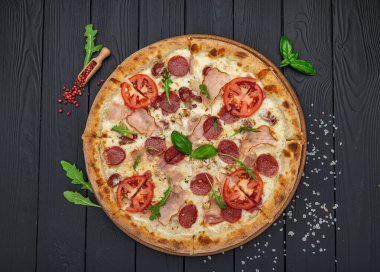 Mozzarella peyniri, salam, tavuk eti, sığır eti, jambon, domates sosu ve biber baharatlı pizza.