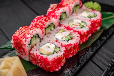 Yengeç, avokado, salatalık ve tobiko havyarlı California suşisi. Japon yemeği.