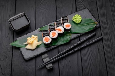 Maki somonla yuvarlanıyor. Suşi menüsü. Japon yemeği..