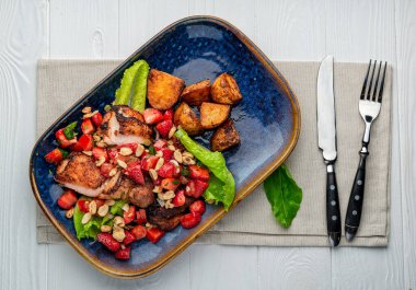 Çilekli ördek göğsü, domates, fındık ve fırında patates. Sağlıklı ve lezzetli yemekler. Menü için fotoğraf.