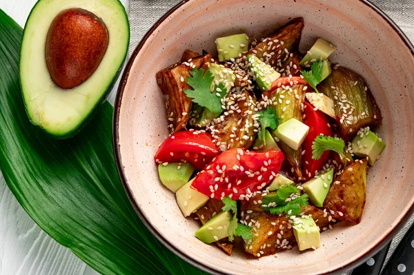 Fried eggplant with avocado, tomatoes and sesame seeds. Asian cuisine. Delicious and healthy food. Photo for the menu.