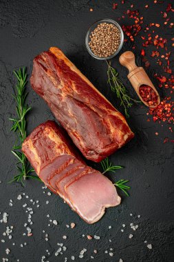 Smoked jerky on a dark background. Natural product from organic farm, produced by traditional methods