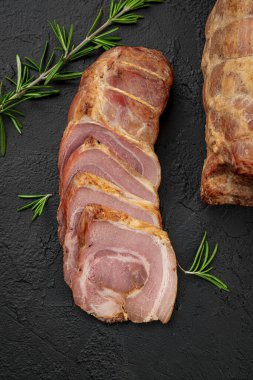 Smoked pork roll with spices on a dark background. Photo for advertising