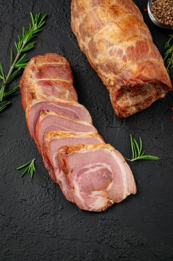 Smoked pork roll with spices on a dark background. Photo for advertising