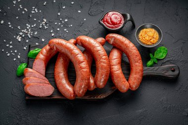 Vakum ambalajında füme sosis. Üst Manzara. Siyah bir arkaplanda.