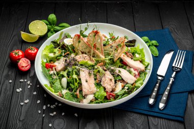 Siyah ahşap masada beyaz tabakta taze sezar salatası. Üst Manzara. Restoranda yemek servisi. Sağlıklı gıda konsepti. Menü için fotoğraf