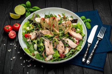 Siyah ahşap masada beyaz tabakta taze sezar salatası. Üst Manzara. Restoranda yemek servisi. Sağlıklı gıda konsepti. Menü için fotoğraf