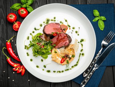 Salata ve humus ile dana madalyonu. Restoranda yemek servisi. Sağlıklı gıda konsepti. Menü için fotoğraf