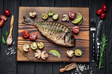 Izgara Dorada balığı, baharat, otlar ve limonla birlikte ızgara tabağında deniz çamı. Sebzeli kızarmış balık.