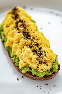 Guacamole ve zeytinli kızarmış ekmek. Tabakta sağlıklı ve lezzetli bir kahvaltı.