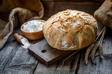 Tahta bir masada taze ev yapımı ekmek. Sağlıklı yiyecekler. Eski bir tarife göre fırında ekmek pişirmek..