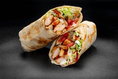 Beef shawarma on a dark background. Shawarma with beef in pita bread. Photo for the menu